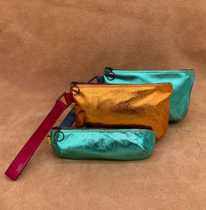 Soft leather pencil case next to 2 large bags in electric colours